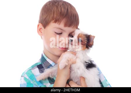 Niedlicher kleiner Junge umarmt niedlichen kleinen Welpen Stockfoto