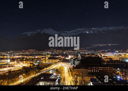 Nachtansicht über die Stadt innsbruck mit Bergkette und Sternen am Himmel Stockfoto