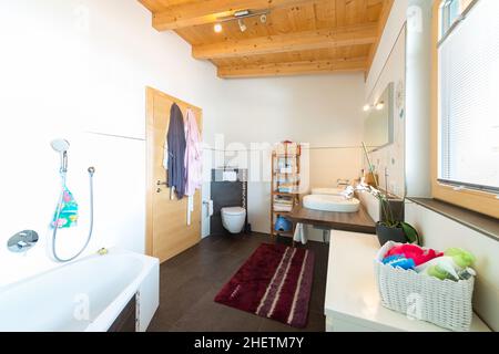 Badezimmer mit Badewanne Waschbecken Toilette in warmen Holzhaus Stockfoto