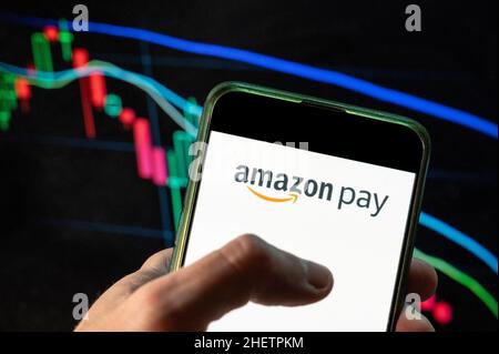 China. 09th Dez 2021. In dieser Abbildung ist das amerikanische Online-Zahlungsplattform von Amazon, Amazon Pay, Logo auf einem Smartphone mit einem wirtschaftlichen Börsenindex im Hintergrund zu sehen. (Foto von Budrul Chukrut/SOPA Images/Sipa USA) Quelle: SIPA USA/Alamy Live News Stockfoto