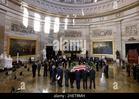 Washington, DC, USA. 12th Januar 2022. Mitglieder des US-Senats stehen in einem Kreis um die mit einer Flagge drapierte Schatulle des ehemaligen Mehrheitsführers des Senats, Harry Reid, als er am 12. Januar 2022 in Washington, DC, in der Rotunde des US-Kapitols im Staat liegt. Der Demokrat Reid vertrat Nevada mehr als 30 Jahre lang im Kongress, acht davon als Mehrheitsführer des Senats. Kredit: Chip Somodevilla/Pool Über Cnp/Media Punch/Alamy Live News Stockfoto