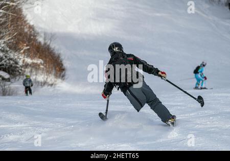 Adaptives Skifahren mit einem Bein : behinderter Skirennfahrer ein drei-Tracker, oder ein-beinige Skifahrer Training Kinder, wie man im Stowe Mountain Resort Ski Stockfoto