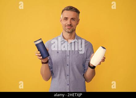 Guy wählen Shampoo-Flasche oder Haarspülung. Tägliche Gewohnheiten und persönliche Pflege. Stockfoto