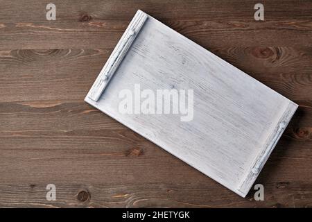 Weißes Holztablett auf einem braunen Holztisch. Gerichte, die im Menülayout angezeigt werden Stockfoto