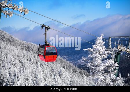 Bergskiresort-Gondel. Winterlandschaft mit Pinien bedeckt mit Schnee. Stockfoto