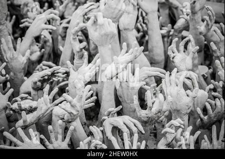 WAT RONG KHUN - WEISSER TEMPEL, CHIANG RAI THAILAND - CA. MAI 2018. Die Skulptur aus Hunderten überstreuenden Händen, die ein ungebremst begehrtes Verlangen symbolisieren. Stockfoto