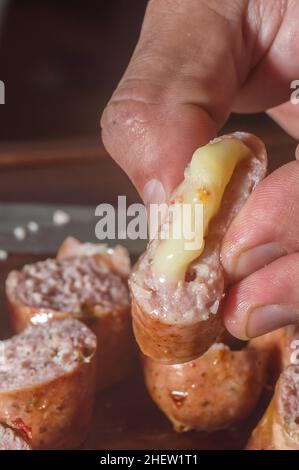 Wurst in Scheiben geschnitten ​​on ein Holzbrett mit Käsestücken im Inneren der Wurst, selektive Fokus und Kopierer Platz Stockfoto