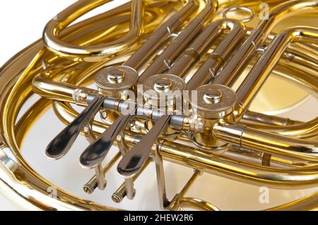 Detail aus Messing und silbernem Horn oder Horn mit Ventilen auf weißem Hintergrund Stockfoto