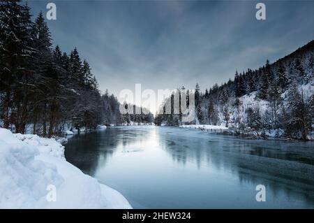 Blick auf eine Winterlandschaft mit gefrorenem plansee und verschneiten Wäldern in tirol österreich Stockfoto