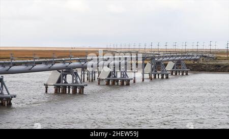 Kanal Wasserlauf Wasserstraße der Wasserversorgung mit Wasserleitung in der Landschaft. Wasserpumpe auf einem Fluss. Stahlrohr für Verteilung Bewässerungssystem Stockfoto