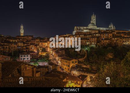 Atemberaubende nächtliche Stadtlandschaft mit zwei Wahrzeichen: Torre del Mangia auf der rechten Seite und die Kathedrale von Siena auf der linken Seite, Toskana, Italien Stockfoto