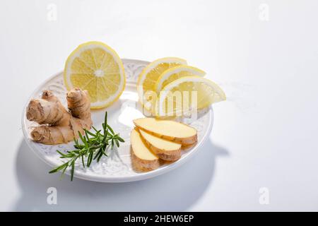 Infusionstee mit Ingwer, Zitrone und Kräutern, serviert in einer weißen Porzellanschale. Speicherplatz kopieren. Stockfoto