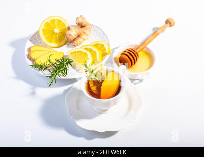 Infusionstee mit Ingwer, Zitrone und Kräutern, serviert in einer weißen Porzellanschale. Speicherplatz kopieren. Stockfoto