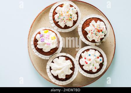 Karottenkuchen Cupcakes mit Frischkäse Zuckerguss mit Streuseln. Draufsicht. Stockfoto