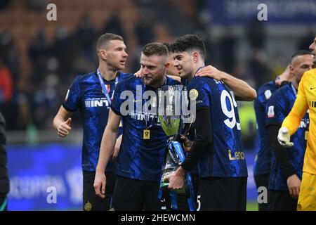 Mailand, Italien. 12th Januar 2022. Alessandro Bastoni und Milan Skriniar vom FC Internazionale feiern mit der italienischen Supercup-Trophäe nach dem Spiel zwischen dem FC Internazionale und dem Juventus FC im Stadio Giuseppe Meazza, Mailand, Italien, am 12. Januar 2022. Kredit: Giuseppe Maffia/Alamy Live Nachrichten Stockfoto