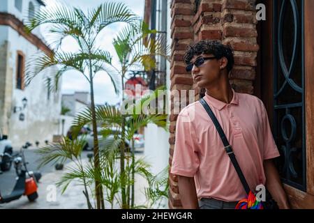 Porträt eines attraktiven und stilvollen jungen lateinamerikanischen nicht-binären Teenagers, selbstbewusst und glücklich mit ihrer Geschlechtsidentität, im Freien