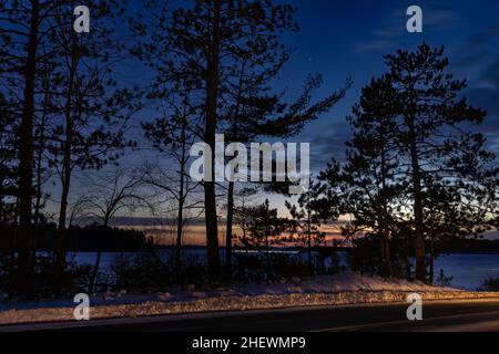 Ein Schneemobiler, der die Chippewa-Blüte bei Dämmerung im Norden von Wisconsin überquert. Stockfoto