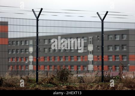 Halberstadt, Deutschland. 10th Januar 2022. Ein Zaun mit einer Krone aus NATO-Draht sichert das Gelände der zentralen Anlaufstelle für Asylsuchende (ZAST). Das ZAST ist in einer ehemaligen NVA-Kaserne untergebracht, in der früher die DDR-Grenztruppen ausgebildet wurden. (Luftaufnahme mit einer Drohne) Quelle: Matthias Bein/dpa-Zentralbild/dpa/Alamy Live News Stockfoto