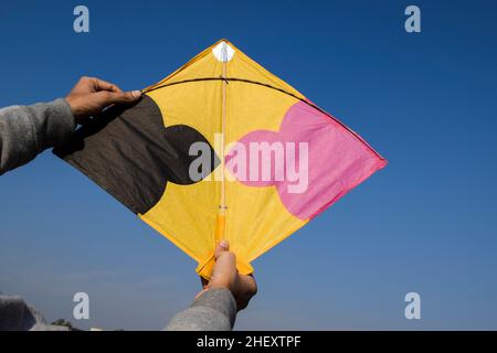 Boy Flying Kite auf Indian Kite Flying Festival von Makarsankranti, Lohri, Pongal oder Uttarayan mit klarem Himmel Hintergrund. Leerzeichen zum Schreiben von Text oder f Stockfoto