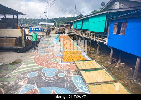 Sandakan, Malaysia - 06. Januar 2022: Fischerdorf in der Nähe des Zentrums von Sandakan, Borneo. Fische werden auf den Planken des Piers im Tropenland getrocknet Stockfoto