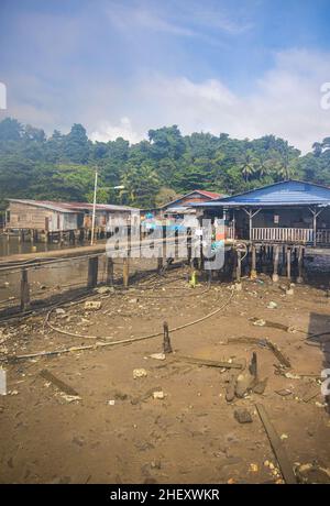 Sandakan, Malaysia - 06. Januar 2022: Fischerdorf in der Nähe des Zentrums von Sandakan, Borneo. Arme Hütten auf Stelzen über dem Küstenwasser am Ufer. Stockfoto