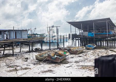 Sandakan, Malaysia - 06. Januar 2022: Fischerdorf in der Nähe des Zentrums von Sandakan, Borneo. Arme Hütten auf Stelzen über dem Küstenwasser am Ufer. Stockfoto