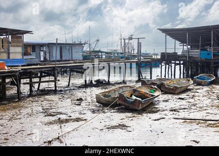 Sandakan, Malaysia - 06. Januar 2022: Fischerdorf in der Nähe des Zentrums von Sandakan, Borneo. Arme Hütten auf Stelzen über dem Küstenwasser am Ufer. Stockfoto