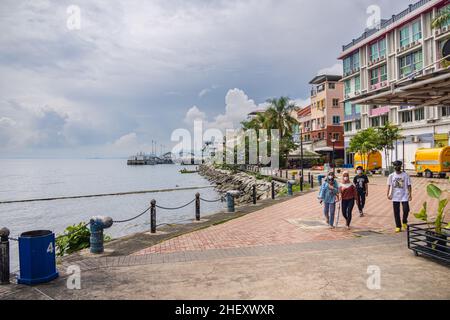 Sandakan, Malaysia - 6. Januar 2022: Der Hafen der Kleinstadt in borneo. Alte und heruntergekommenen Promenade mit großen Mengen an Plastikmüll auf der St. Stockfoto