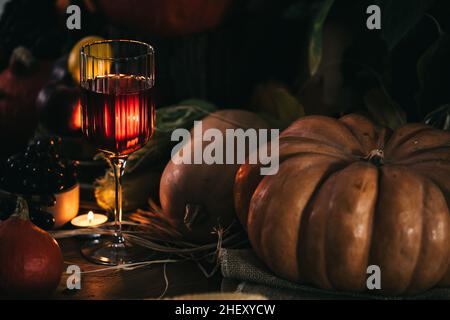 Ein Glas Roséwein oder Apfelwein im Weinglas in stimmungsvoller Herbststimmung. Herbstprätenzen Stockfoto