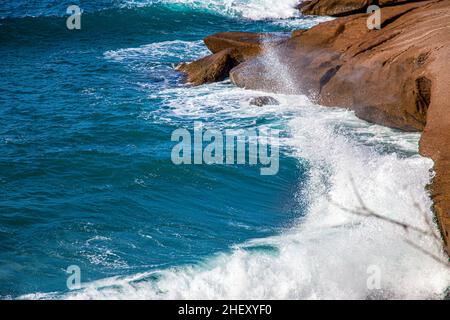 Die Wellen des Atlantischen Ozeans stürzen auf Felsen mit Spritzern in Teneriffa Stockfoto