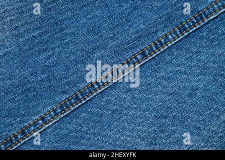 Nahaufnahme der blauen Jeans-Textur mit diagonaler Naht. Hintergrund aus Denim-Textil. Bekleidungsqualität. Stockfoto