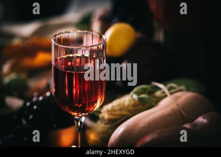 Ein Glas Roséwein oder Apfelwein im Weinglas in stimmungsvoller Herbststimmung. Herbstprätenzen Stockfoto