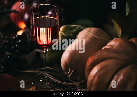 Ein Glas Roséwein oder Apfelwein im Weinglas in stimmungsvoller Herbststimmung. Herbstprätenzen Stockfoto