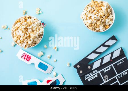 Kino Minimal Konzept. Word-Film, Popcorn, Klappbrett, 3D Gläser und Tickets Draufsicht flach lag auf blauem Hintergrund Stockfoto