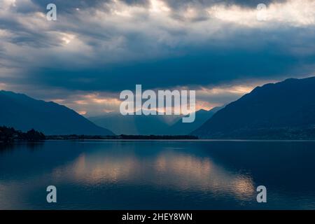 Dramatische Gewitterwolken über dem Lago Maggiore, die sich auf der Wasseroberfläche spiegeln. Stockfoto