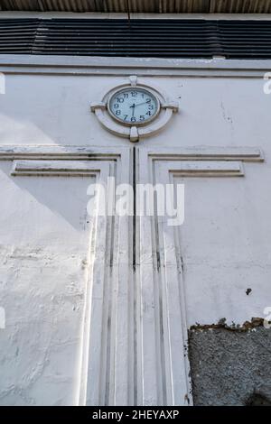 Öffentliche Stadtuhr im Vintage- und Retro-Stil zeigt die Zeit auf der weißen Wandornament mit Blick auf den niedrigen Winkel Stockfoto