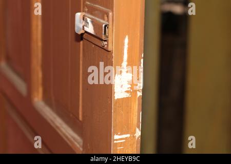 Nahaufnahme der Holztür an der Seite sind weiße Kratzer und der Riegel zu sehen Stockfoto