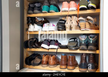 Sammlung von verschiedenen Schuhen in Schuhregal für die Lagerung, chaotisch und Bedürfnisse zu organisieren, Kleiderschrank mit Regalen im Haus Innenarchitektur stilvolle Dekoration Stockfoto