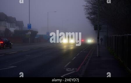 Merton, London, Großbritannien. 13. Januar 2022. Pendler, die in den Vororten im Südwesten Londons unterwegs sind, treffen am frühen Morgen vor Sonnenaufgang auf starken Nebel und Nebel. Quelle: Malcolm Park/Alamy Live News. Stockfoto