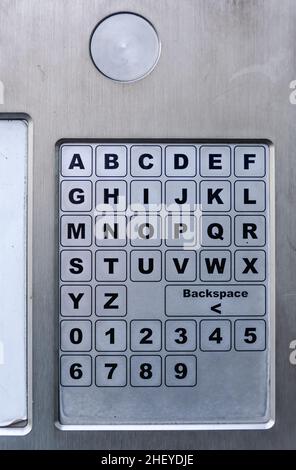 Alphabete und Zahlen berühren die Tastatur des automatischen Parkautomaten auf dem Bürgersteig Stockfoto