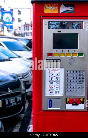 Eine Reihe von Autos parken und eine Vereinbarung mit der roten automatischen Parkmaschine eine der Stadt Bürgersteig Stockfoto