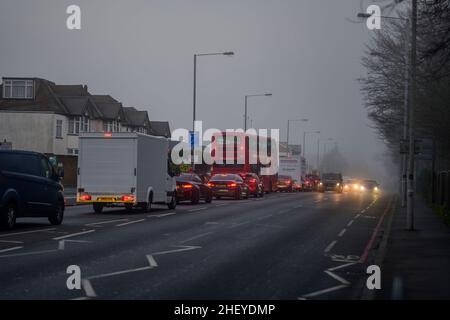 Merton, London, Großbritannien. 13. Januar 2022. Pendler, die am frühen Morgen in einer Schlange in den Vororten im Südwesten Londons in Richtung Zentrum von London fahren, treffen vor Sonnenaufgang auf starken Nebel und Nebel. Quelle: Malcolm Park/Alamy Live News. Stockfoto