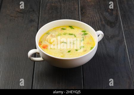 Schüssel mit Seehechtsuppe mit Rahm und Karotten auf einem Tisch Stockfoto