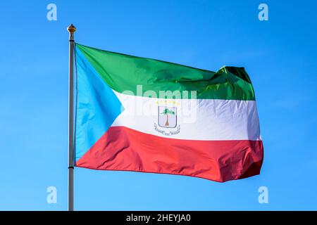 Die Nationalflagge von Äquatorialguinea fliegt im Wind mit vollem Mast gegen den blauen Himmel. Stockfoto