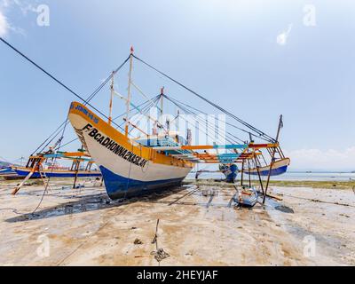 Wartungsarbeiten an einem traditionellen philippinischen Fischerboot, einem Basnigan, bei Ebbe im Dorf Tinoto, Maasim in der Provinz Sarangani in s Stockfoto