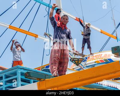 Wartungsarbeiten an einem traditionellen philippinischen Fischerboot, einem Basnigan, bei Ebbe im Dorf Tinoto, Maasim in der Provinz Sarangani in s Stockfoto