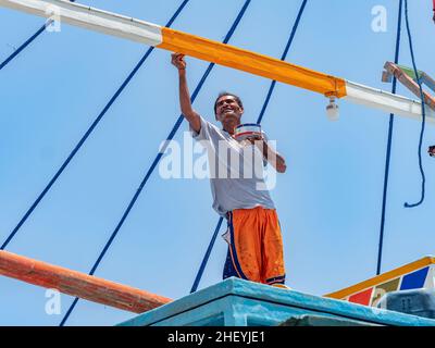 Wartungsarbeiten an einem traditionellen philippinischen Fischerboot, einem Basnigan, bei Ebbe im Dorf Tinoto, Maasim in der Provinz Sarangani in s Stockfoto