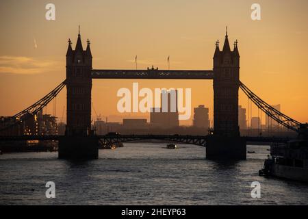 Stadtarbeiter gehen über die London Bridge, während die Sonne nach Osten aufgeht, während sie an einem klaren Wintermorgen in die City of London reisen, City of London, Großbritannien 13th. Januar 2022. London, England, Vereinigtes Königreich Kredit: Jeff Gilbert/Alamy Live News Stockfoto