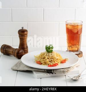 Würzige Spaghetti Pasta mit Käse, serviert mit Ice Tea. Concept Menu Card im Café oder Restaurant Stockfoto