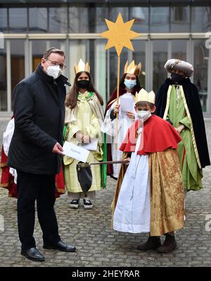 Erfurt, Deutschland. 13th Januar 2022. Der Ministerpräsident Thüringens, Bodo Ramelow (die Linke, l), empfängt fünf Liedersänger aus Erfurt im Thüringer Staatskanzlei und überreicht ihnen eine Spende. Unter dem Motto „Get Healthy - Stay Healthy. Ein Kinderrecht weltweit“, steht der Schwerpunkt der diesjährigen Epiphany auf der Gesundheitsversorgung für Kinder in Afrika. Ministerpräsident Ramelow überreichte eine Spende in Höhe von 500 Euro an die Kindermissionarorganisation "die Sternsinger" e.V. Quelle: Martin Schutt/dpa-Zentralbild/dpa/Alamy Live News Stockfoto